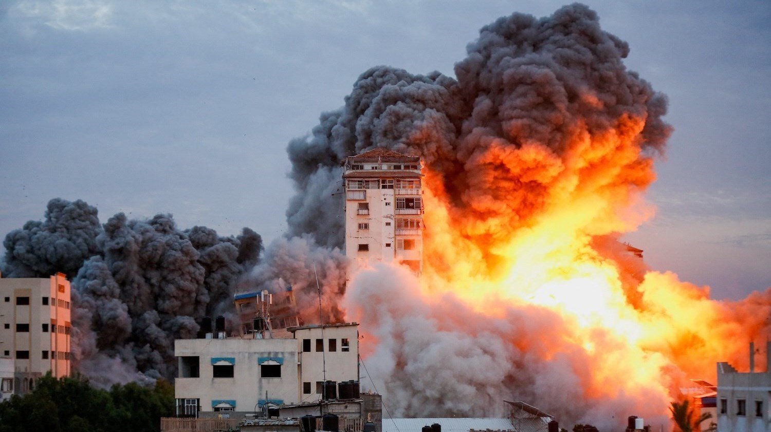 Smoke and flames pour from a high-rise building after an Israeli force strike in Gaza City. (Photo: Reuters/Bangkok Post)